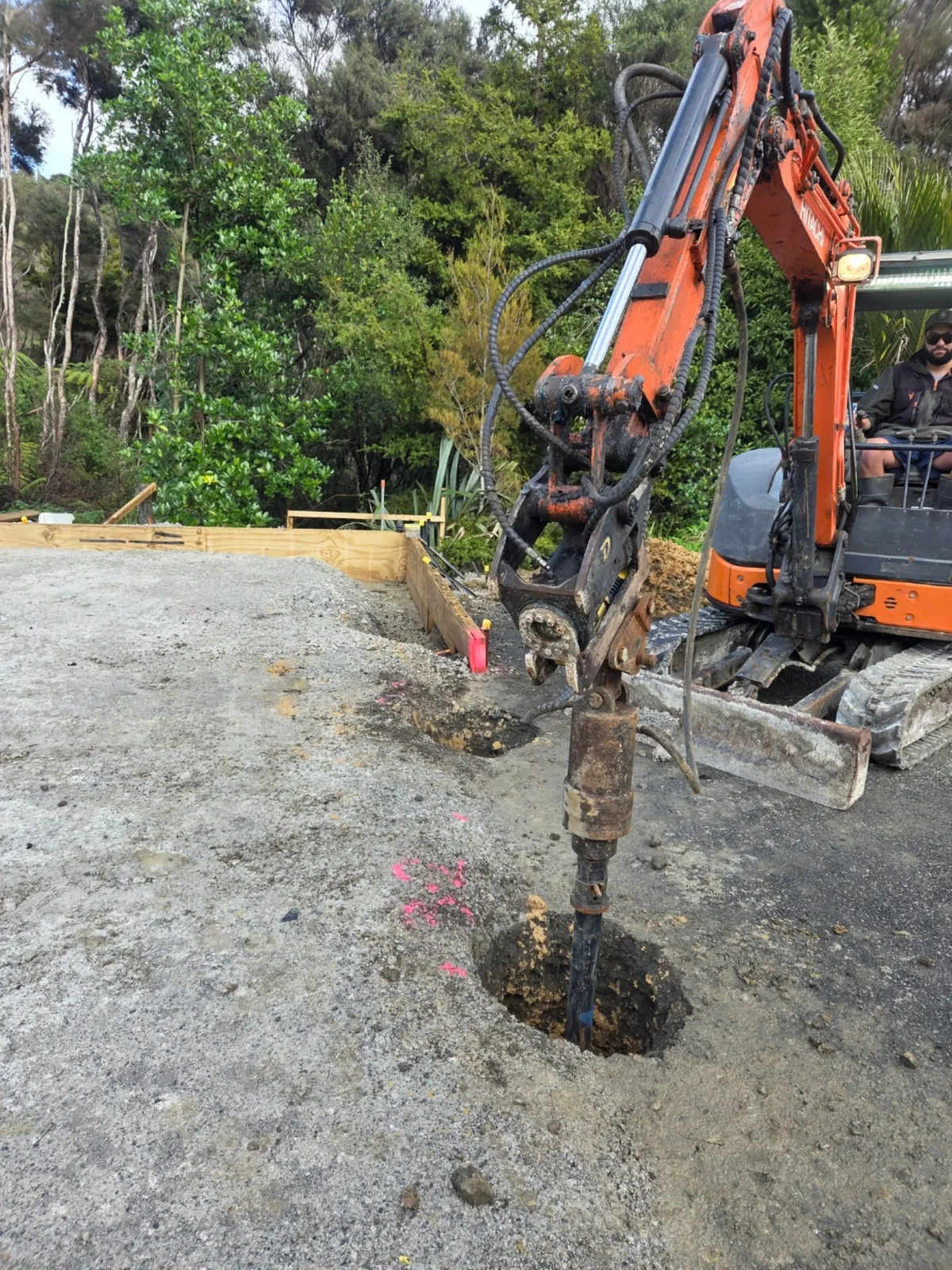 Excavator auger drilling hole in Auckland